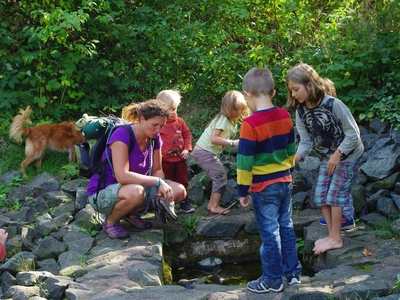 Kinder und Frau um eine Wasserstelle